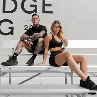 all black sneakers displayed by man and women models