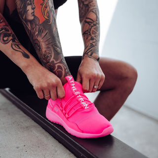 tattooed model wearing pink sneakers