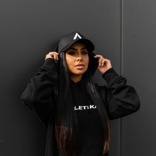 women shows off black and white baseball cap