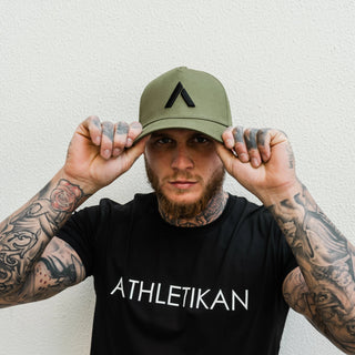 khaki cap on model wearing black t shirt