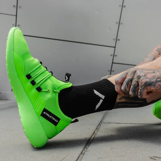 model displays black socks with green trainers