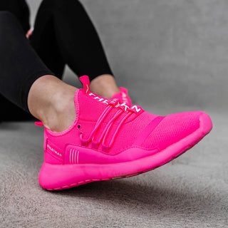 neon pink trainers on ladies foot in foreground