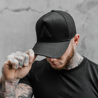 model shows off black baseball cap white looking downwards